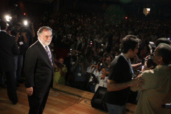 Coppola on the stage while the cameras click